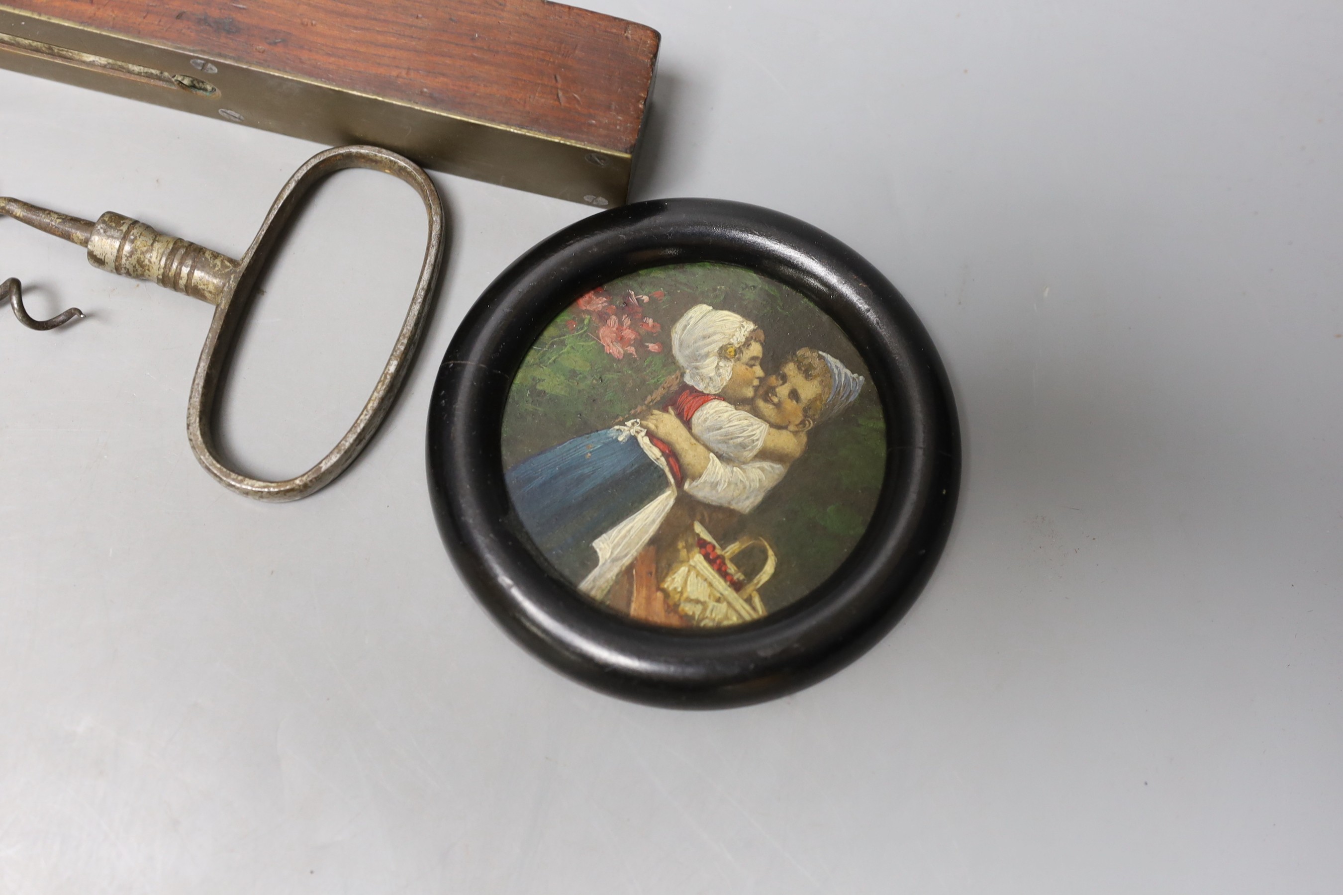 A George III framed silhouette, two corkscrews, spirit level and circular miniature painting